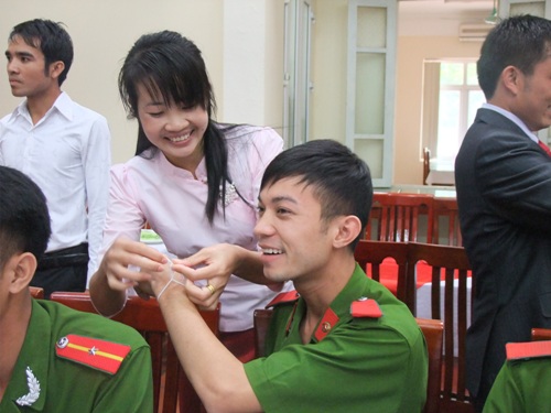Học viên Việt Nam hào hứng được các bạn Lào và Campuchia buộc chỉ vào tay mình
